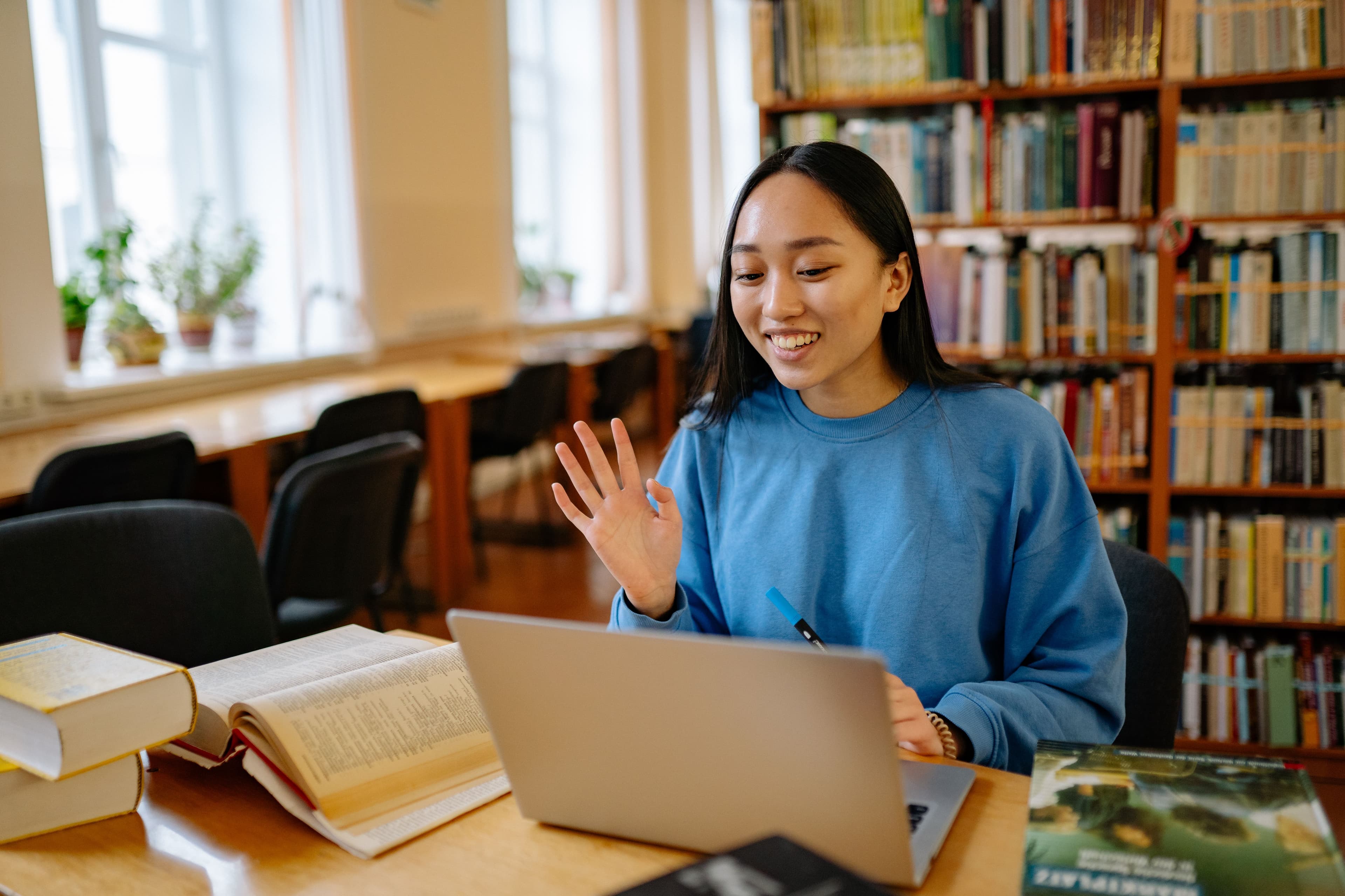 A student learning with a laptop in a bright library
